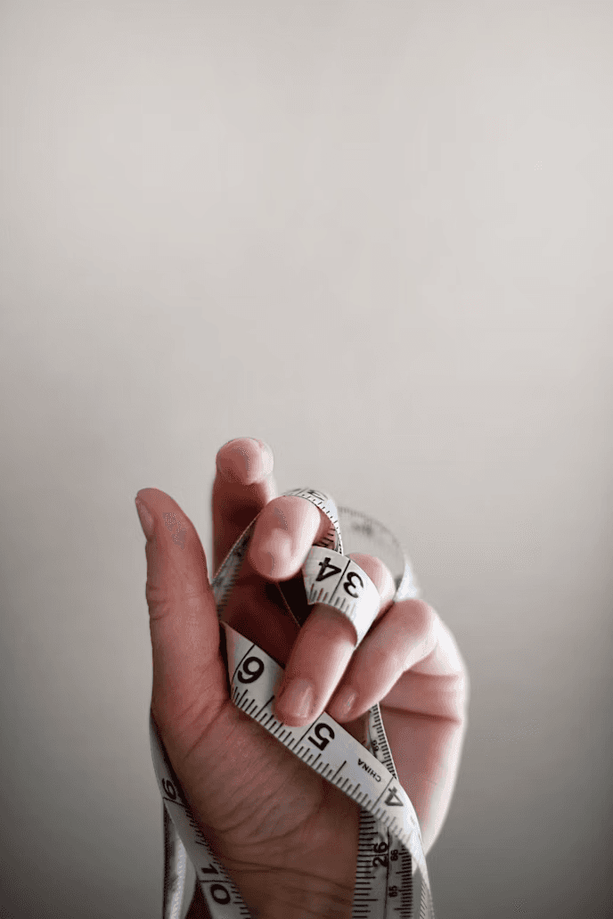 A tape measure held in one hand, ready to take a measurement